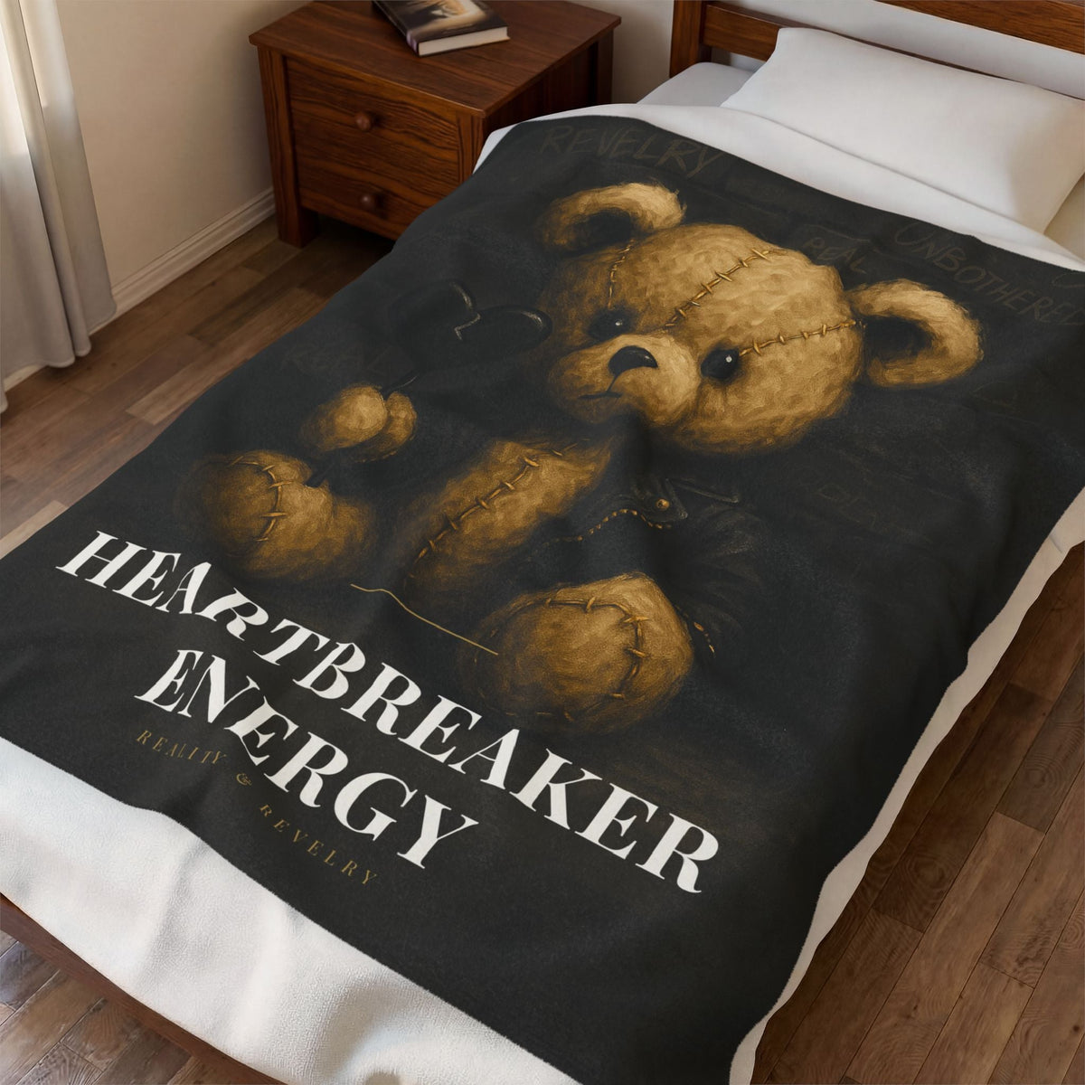 The 50 by 60 inch Heartbreaker Energy blanket draped over a made bed in a warm bedroom, showing sofa throw scale.