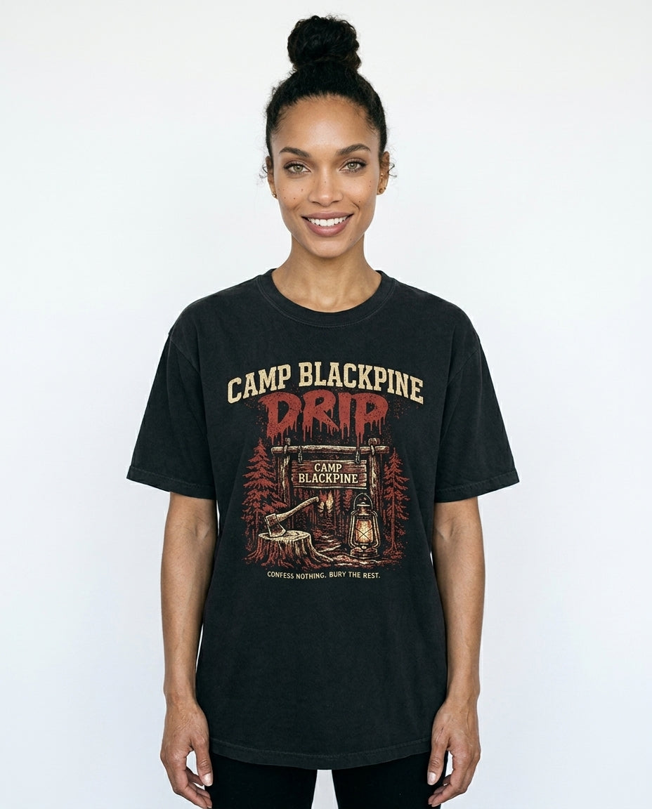 Smiling woman wearing the black Camp Blackpine Drip garment-dyed tee on a white studio background