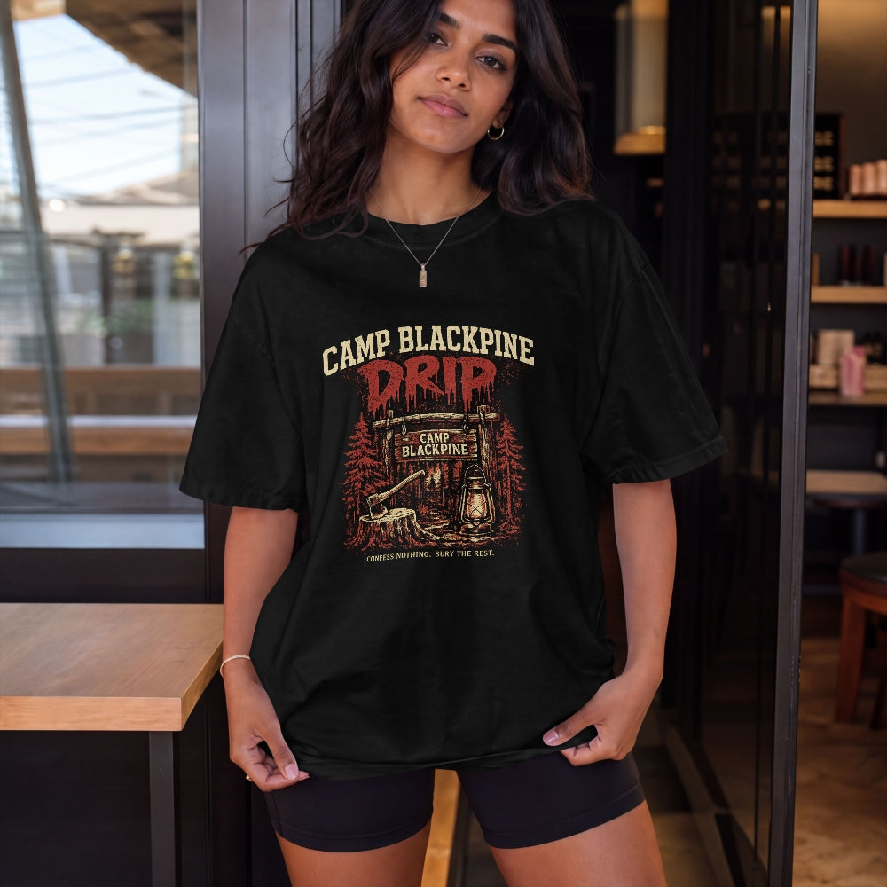 Model in black Camp Blackpine Drip oversized tee at a cafe