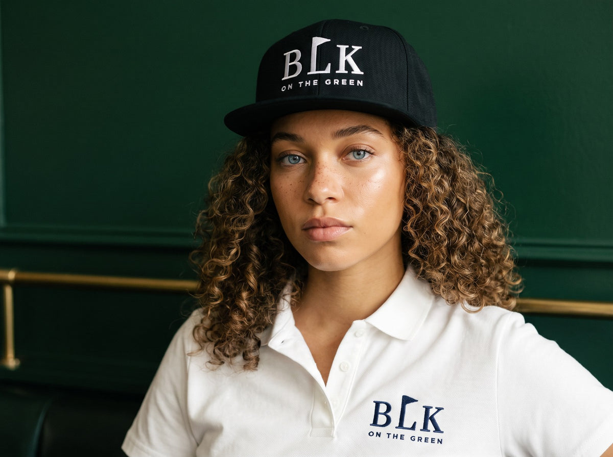 Close portrait in the BLK on the Green Tee Box Snapback and Women's Clubhouse Polo