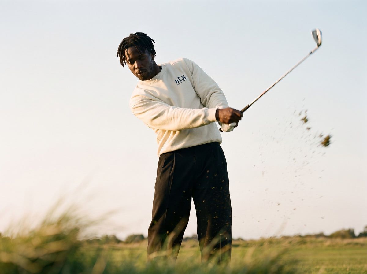 Man mid swing in the cream BLK on the Green Nineteenth Hole Sweatshirt
